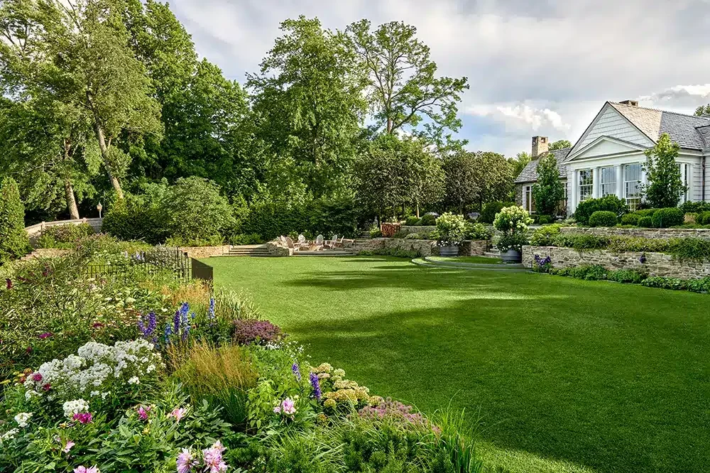 A home with a large lawn and flowers.